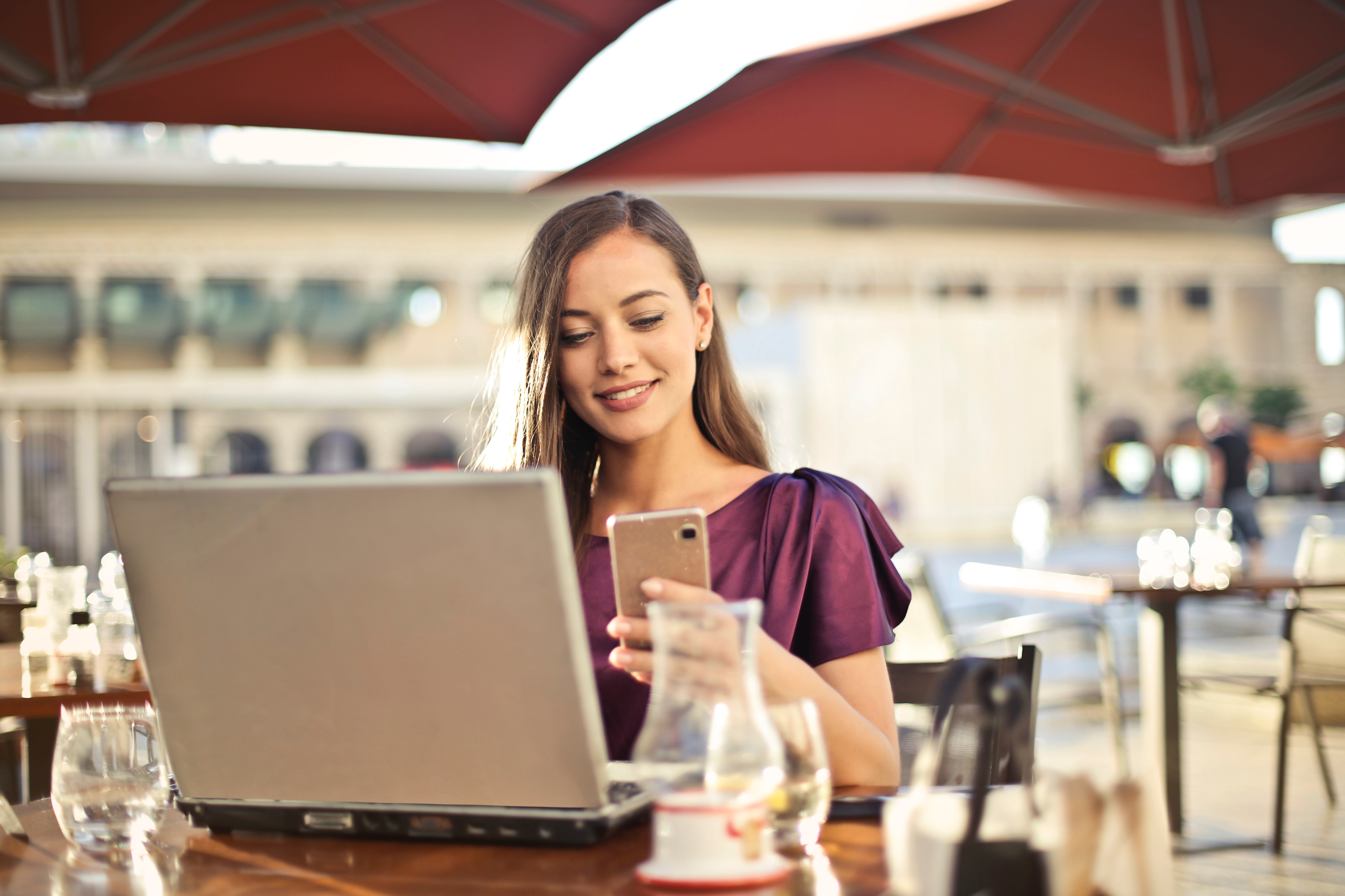 woman-wearing-purple-shirt-holding-smartphone-white-sitting-826349